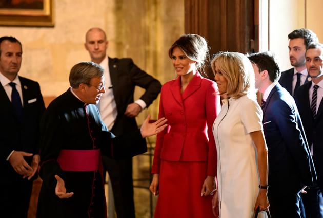 Les Premières dames Melania Trump (en rouge) et Brigitte Macron (en blanc), reçues par Mgr Patrick Chauvet (g), le 13 juillet 2017 à la cathédrale Notre-Dame de Paris [Martin BUREAU / POOL/AFP]