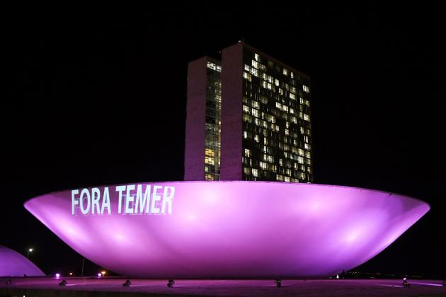 "Temer dehors" projeté sur le bâtiment du parlement à Brasilia le 2 août 2017 qui doit décider s'il donne suite ou non à une procédure pouvant coûter son mandat au président brésilien [EVARISTO SA / AFP]