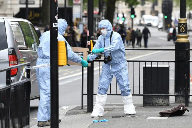 Des officiers de la police scientifique avec un couteau confisqué à un homme qui a été arrêté près du Parlement de Westminster à Londres, le 27 avril 2017 [Justin TALLIS / AFP]