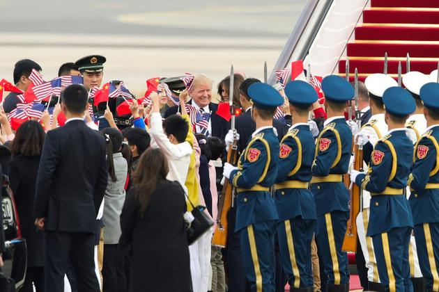 Le président américain Donald Trump (c) et son épouse Melania à leur arrivée à l'aéroport de Pékin, le 8 novembre 2017 [Lintao Zhang / POOL/AFP]