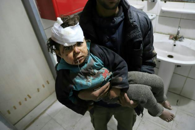 Un enfant blessé est transporté dans une clinique improvisée dans la localité de Hazeh, dans l'enclave rebelle de la Ghouta orientale, à la suite de bombardements attribués au régime syrien, le 15 mars 2018 [AMER ALMOHIBANY / AFP]