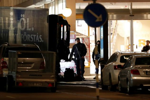 Des policiers surveillent, le 8 avril 2017, le camion volé utilisé la veille pour foncer sur la foule dans une rue commerçante de Stockholm, tuant cinq personnes [Odd ANDERSEN / AFP/Archives]