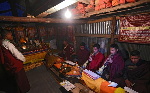 Des moines bouddhistes prient et jouent de la musique traditionnelle après leur séance de jogging, le 14 février 2018 à Sindkhukot, au nord-est de Katmandou, au Népal [PRAKASH MATHEMA / AFP]
