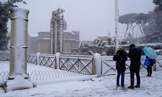 Des touristes visitent Rome sous la neige, le 26 février 2018 [Vincenzo PINTO / AFP]