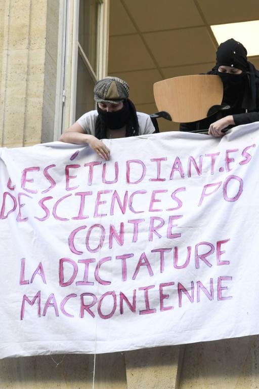 Des étudiants de Sciences-Po déploient une banderole devant l'entrée de la grande école le 18 avril 2018 à Paris [Bertrand GUAY / AFP]
