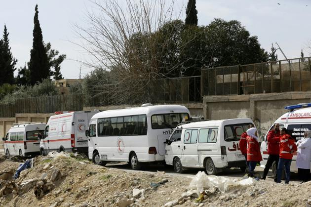 Des ambulances du Croissant rouge syrien attendent une éventuelle évacuation de blessés de l'enclave rebelle dans la Ghouta orientale, au passage d'Al-Wafidine, le 1er mars 2018 [LOUAI BESHARA / AFP]