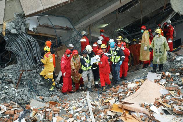 Des sauveteurs transportent le corps d'une victime du violent séisme qui a atteint la ville de Hualien à Taïwan, le 7 février 2018. [Paul YANG / AFP]