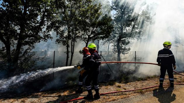 Des pompiers tentent d'éteindre un incendie à Artigues, dans le Var, le 25 juillet 2017 [Anne-Christine POUJOULAT             / AFP]