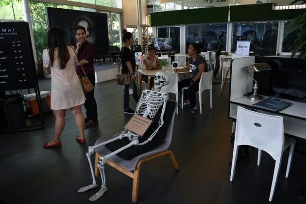 Un squelette trône au milieu du "café de la mort", à Bangkok, le 5 avril 2018 [LILLIAN SUWANRUMPHA / AFP]