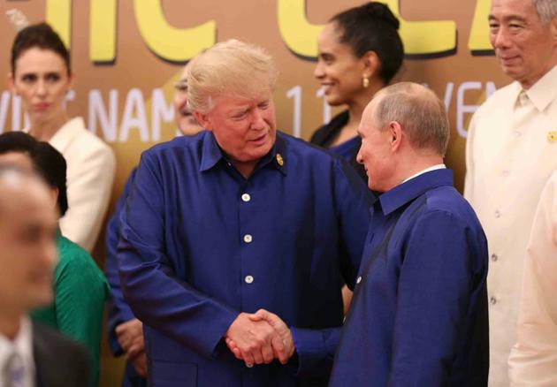 Les présidents américain Donald Trump (G) et son homologue russe Vladimir Poutine(D)se serrent la main en marge du sommet Asie-Pacifique au VIetnam, le 10 novembre 2017.  [ / AFP]