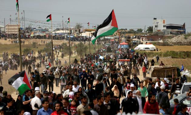 Des milliers de Palestiniens participent aux protestations près de la frontière entre Gaza et l'Etat hébreu, pour le troisième vendredi consécutif, le 13 avril 2018 [MAHMUD HAMS / AFP]
