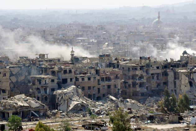Des panaches de fumée s'élevant du camp palestinien de Yarmouk à Damas où le régime syrien bombarde des positions du groupe jihadiste Etat islamique (EI) le 21 avril 2018 [STRINGER / AFP]