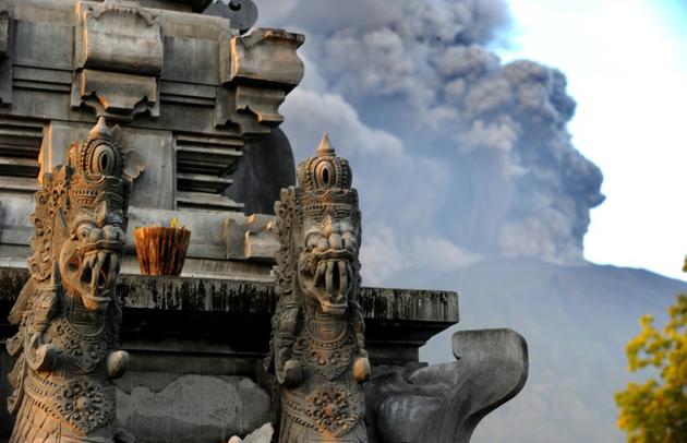Les nuages de fumée crachés par le volcan Agung vus depuis un temple à Bali, le 26 novembre 2017 [SONNY TUMBELAKA / AFP]