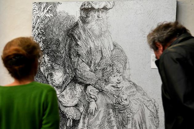 Des visiteurs regardent un agrandissement d'une gravure de Rembrandt au couvent Sainte-Cécile, domicile des éditions Glénat, à Grenoble, le 19 octobre 2017 [JEAN-PIERRE CLATOT / AFP]