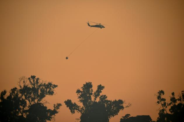 Un hélicoptère participe à la lutte contre l'incendie qui ravage Carpinteria, en Californie, le 12 décembre 2017 [Robyn Beck / AFP]