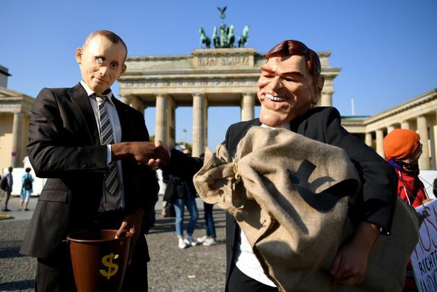Des militants avec des masques de Poutine et Schröeder protestent devant la porte de Brandebourg à Berlin contre la nomination de l'ancien chancelier au conseil de surveillance du géant pétrolier Rosneft, le 29 septembre 2017  [Britta Pedersen / dpa/AFP]