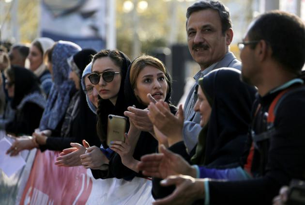 Des Iraniens et des étrangers observent le premier marathon international à Téhéran, le 7 avril 2017 [ATTA KENARE / AFP]