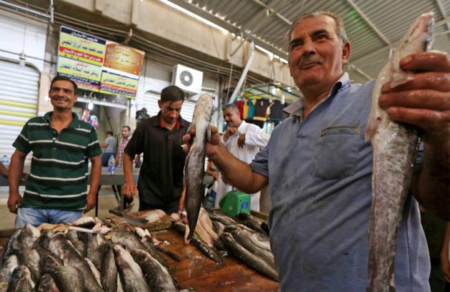 Un vendeur de poisson irakien dans un marché de l'est de Mossoul le 28 juillet 2017 [SAFIN HAMED / AFP]