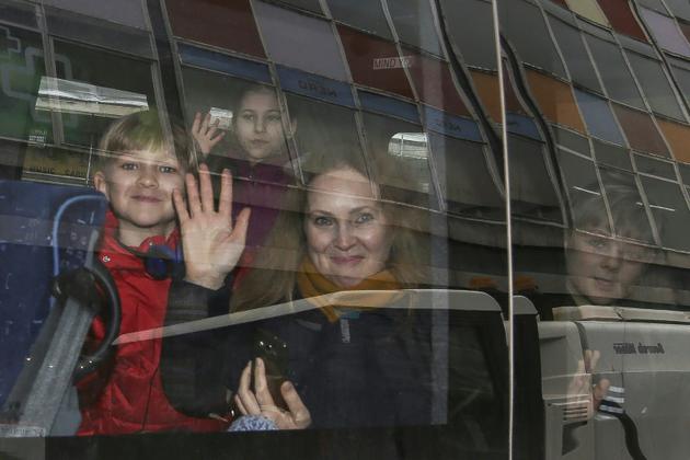 Des personnes font un signe de la main à travers la vitre d'un véhicule après avoir quitté l'ambassade de Russie à Londres, le 20 mars 2018 [Daniel LEAL-OLIVAS / AFP]