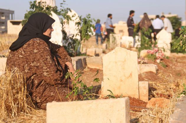 Des Syriens sur les tombes de membres de leur famille au premier jour de l'Aïd al-Adha, la grande fête musulmane du sacrifice, le 1er septembre 2017 à Binnish (Syrie) [Omar haj kadour / AFP]