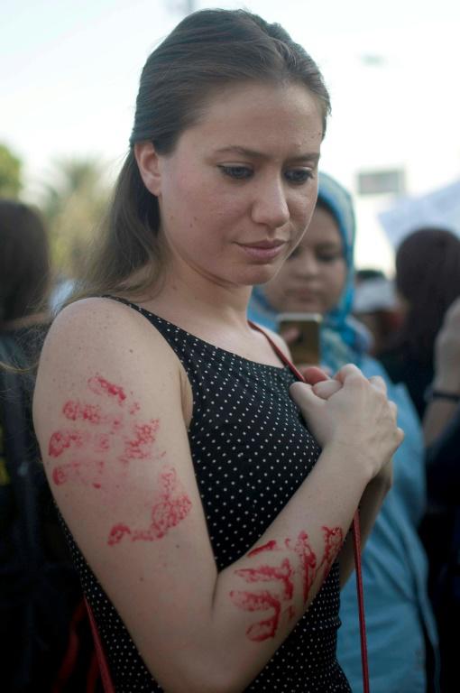 Photo d'une jeune femme arborant sur son bras des empreintes de main peintes en rouge, lors d'une manifestation contre le harcèlement sexuel le 14 juin 2014 au Caire [NAMEER GALAL / AFP/Archives]