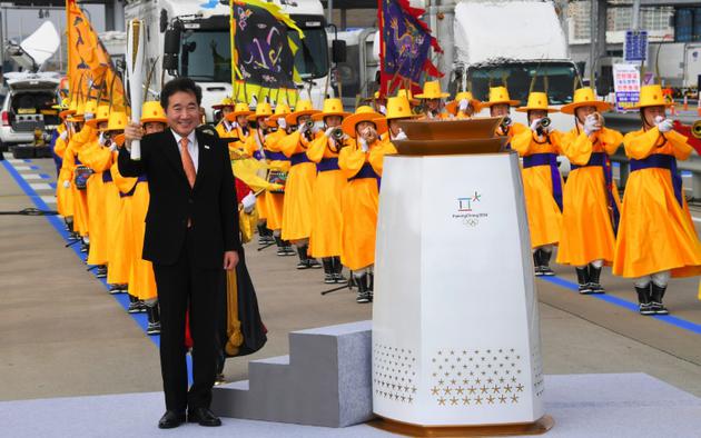 Le Premier ministre sud-coréen Lee Nak-Yon (d) portela flamme olympique, le 1er novembre 2017 à Séoul, lors d'une cérémonie pour son arrivée en Corée du Sud [JUNG Yeon-Je / AFP]