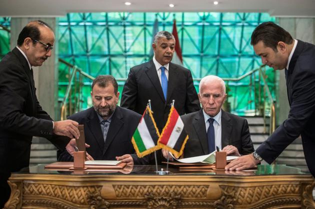 Azzam al-Ahmad (R) du Fatah et Saleh al-Arouri (L) du Hamas signent un accord de réconciliation au Caire le 12 octobre 2017 [KHALED DESOUKI / AFP/Archives]