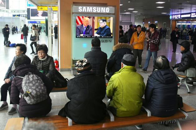 Des personnes regardent un téléviseur montrant des photographies du président américain Donald Trump (G) et du dirigeant nord-coréen Kim Jong Un dans une gare de Séoul, le 9 mars 2018 [Jung Yeon-je / AFP]