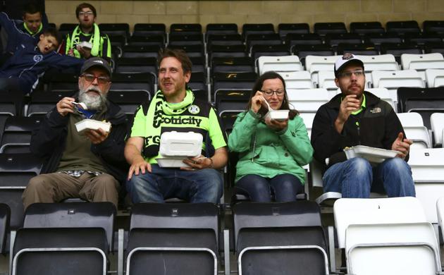 Des supporters du club Forest Green Rovers, dans l'ouest de l'Angleterre, se restaurent dans les tribunes du stade, le 8 août 2017 [GEOFF CADDICK / AFP]