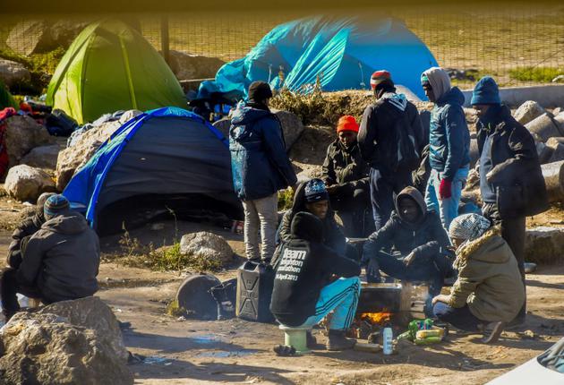 Des migrants près de leurs tentes dans un campement à la périphérie de Calais, le 8 mars 2018 [Philippe HUGUEN / AFP]