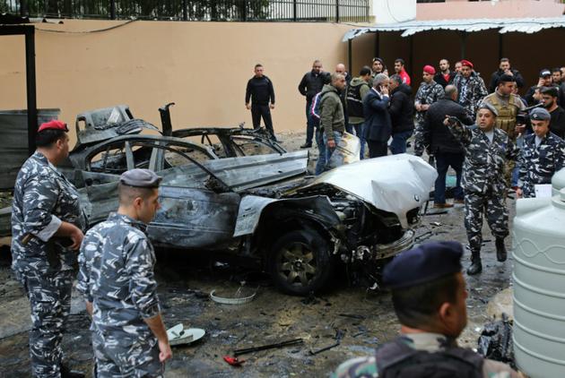 Des forces de sécurité libanaises devant la carcasse d'un véhicule après l'explosion d'une bombe, le 14 janvier 2018 à Saïda [Mahmoud ZAYYAT / AFP]