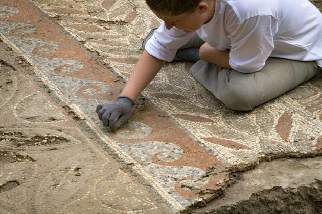 C'est une pièce de monnaie retrouvée sous le système de chauffage qui a permis de dater les mosaïques sur un site gallo-romain à Auch [Eric CABANIS / AFP]