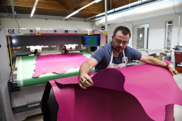Un employé coupe du cuir dans la nouvelle manufacture d'Hermès à Allenjoie (Doubs), le 5 avril 2018 [SEBASTIEN BOZON / AFP]