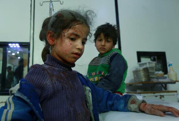 Des enfants syriens blessés attendent d'être soignés dans un hôpital de fortune, après des raids aériens du régime sur la localité de Douma, dans le fief rebelle de la Ghouta orientale, le 23 février 2018  [HAMZA AL-AJWEH / AFP]