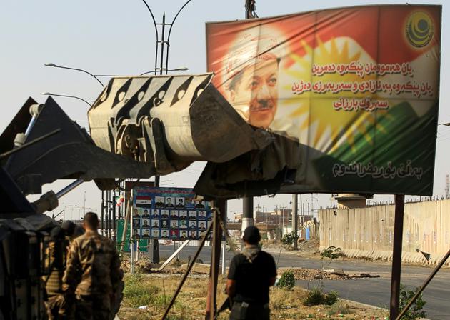 Des soldats irakiens détruisent un panneau à l'effigie de Massoud Barzani à Kirkouk le 16 octobre 2017 [AHMAD AL-RUBAYE / AFP/Archives]