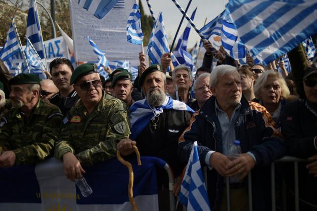 Des vétérans brandissent des drapeaux grecs à Athènes, lors d'une manifestation contre un compromis sur le nom de la Macédoine, envisagé par le gouvernement, le 4 février 2018 [ANGELOS TZORTZINIS / AFP]