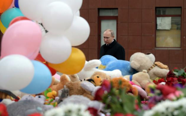 Le président russe Vladimir Poutine dépose des fleurs en hommage aux victimes d'un incendie dans un centre commercial, le 27 mars 2018 à Kemerovo, en Sibérie [Alexey DRUZHININ / SPUTNIK/AFP]