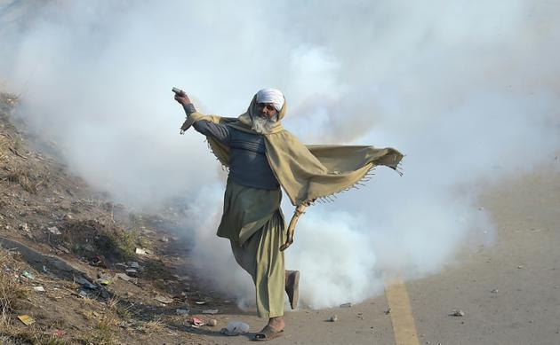 Un manifestant islamiste pakistanais renvoie une grenade lacrymogène sur les forces de l'ordre samedi 25 novembre 2017 à Islamabad [AAMIR QURESHI / AFP]