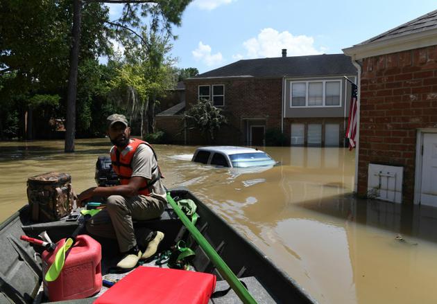 Un secouriste bénévole Matt Clarke recherche des résidents dans un quartie évacué près de la retenue d'eau de Barker à Houston, Texas, le 31 août 2017 [MARK RALSTON / AFP]