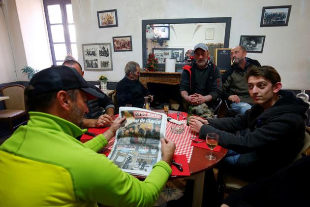 Au Café de de la Paix de Belgodère, en Haute-Corse, des clients discutent des résultats du premier tour des territoriales, le 4 décembre 2017 [Pascal POCHARD-CASABIANCA / AFP]