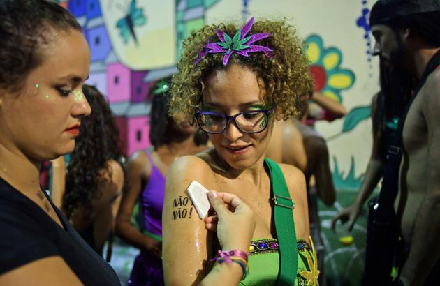 Une femme se fait tatouer "non c'est non", le 7 février 2018 lors du festival de Rio, pour dénoncer le harcèlement sexuel [CARL DE SOUZA / AFP]