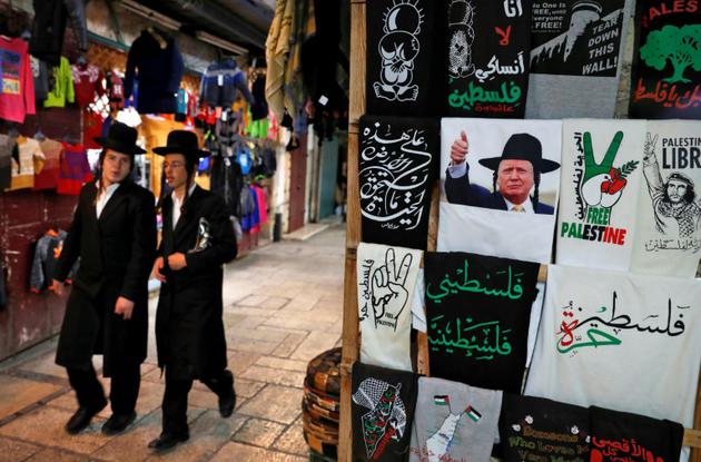 Un t-shirt du président des Etats-Unis en juif orthodoxe à côté d'un vêtement pro-palestinien vendus dans une boutique de la vieille ville de Jérusalem, le 4 décembre 2017 [AHMAD GHARABLI / AFP]