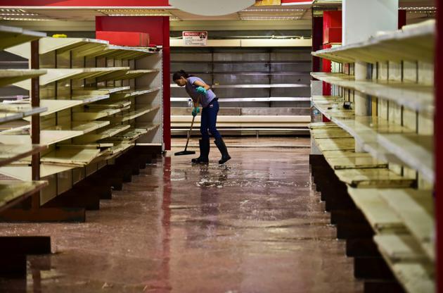Un employé passe la serpillère dans un supermarché à Valencia au Venezuela, le 5 mai 2017 [RONALDO SCHEMIDT / AFP]