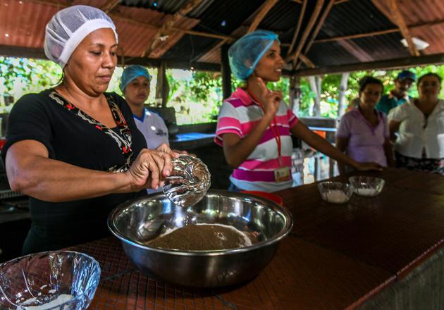 Un cours de cuisine pour apprendre à faire des galettes à partir de la poudre de graines du guaimaro, le 28 février 2018 à Dibulla, en Colombie [Luis ACOSTA / AFP]