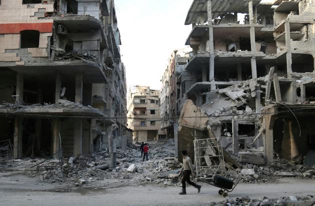Un Syrien au milieu des destructions dans la localité d'Aïn Tarma dans l'enclave rebelle dans la Ghouta orientale, bombardée par le régime, le 2 mars 2018 [Ammar SULEIMAN / AFP]
