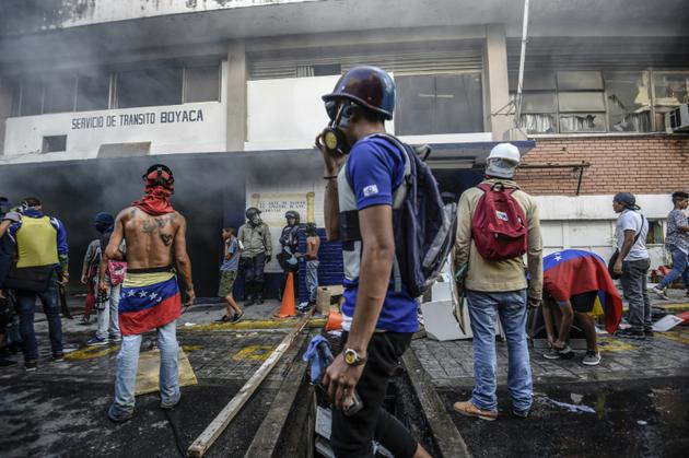 Des manifestants attaquent un poste de police le 30 juillet 2017 à Caracas [JUAN BARRETO / AFP]