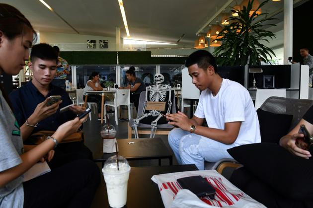 Des clients boivent au "café de la mort", à Bangkok, le 5 avril 2018 [LILLIAN SUWANRUMPHA / AFP]