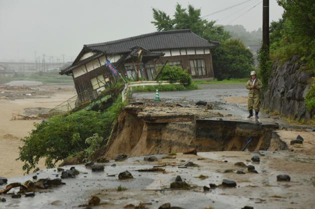 Une route et maison détruites lors de fortes inondations à Asakura, le 7 juillet 2017 au Japon [KAZUHIRO NOGI / AFP]