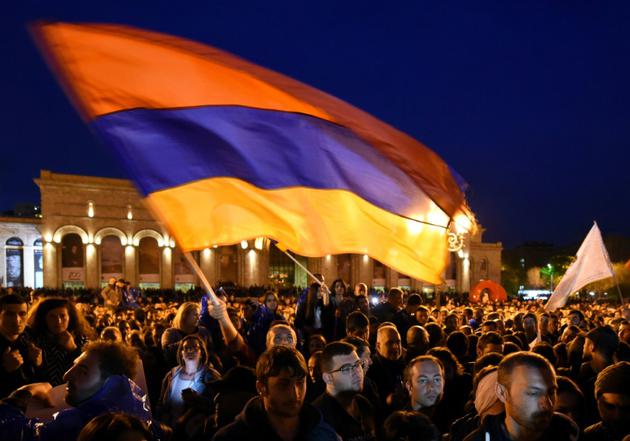 Des opposants arméniens brandissent un drapeau national lors d'une manifestation contre l'ex-président nommé Premier ministre Serge Sarkissian à Erevan, le 20 avril 2018  [Vano SHLAMOV / AFP]