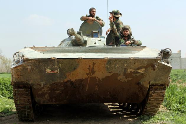 Des membres des forces progouvernementales syriennes dans un tank, le 10 mars 2018 à Aftris, dans la Ghouta orientale [STRINGER / AFP]